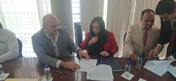 El rector de la UTTN, Edgar Garza Hernández, y Gladys Díaz firman el Convenio. Junto a ellos, Germán Bautista firma como testigo de honor.